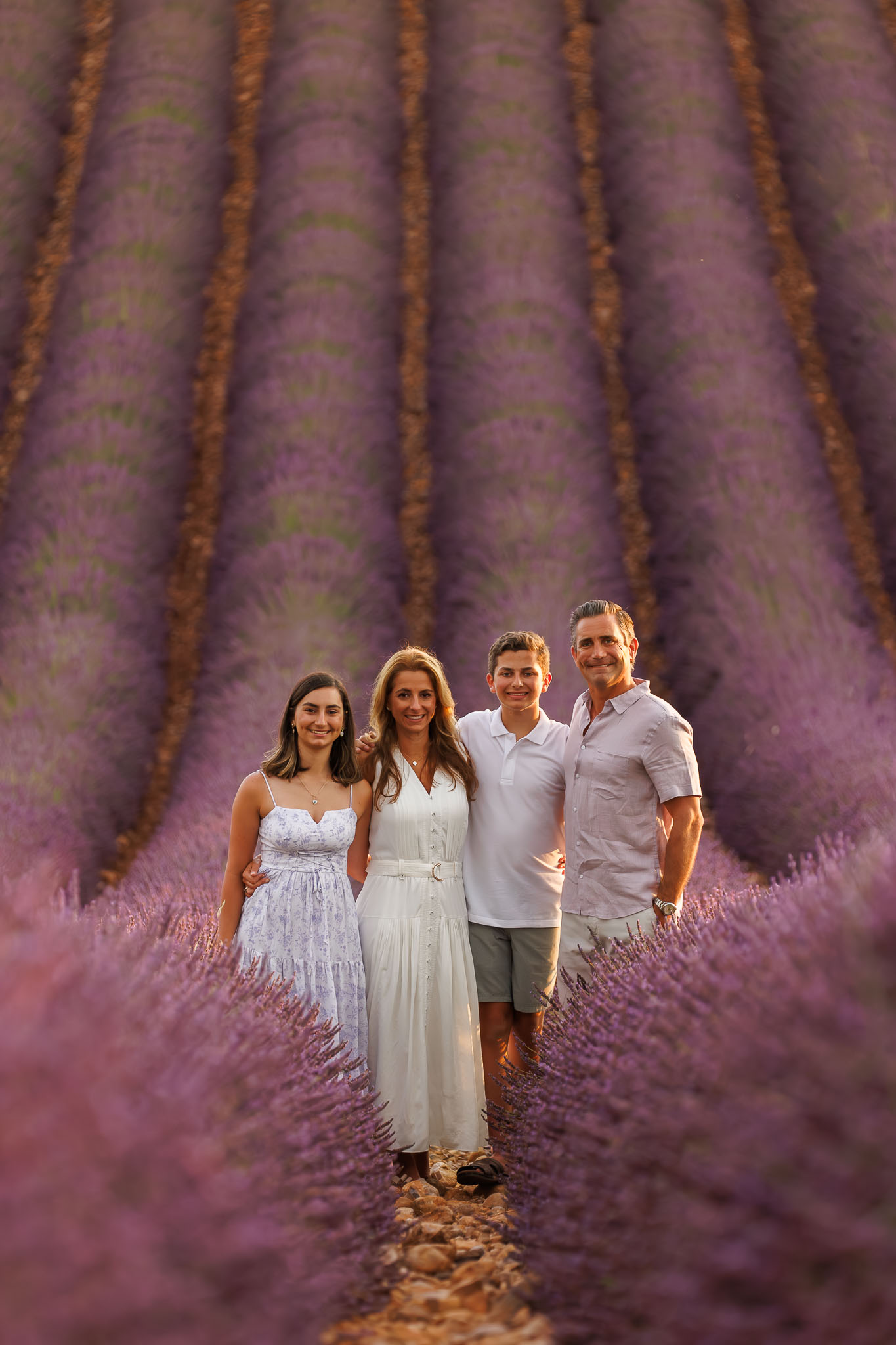 A family fulfilling their dream of a lavender field photoshoot on the Valensole Plateau; professional family portraits during a summer trip to Provence